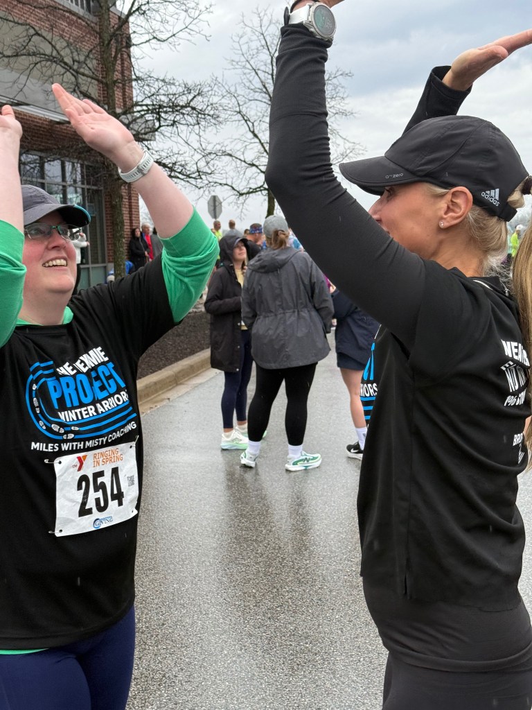 Coach Misty celebrating with a runner at a spring race
